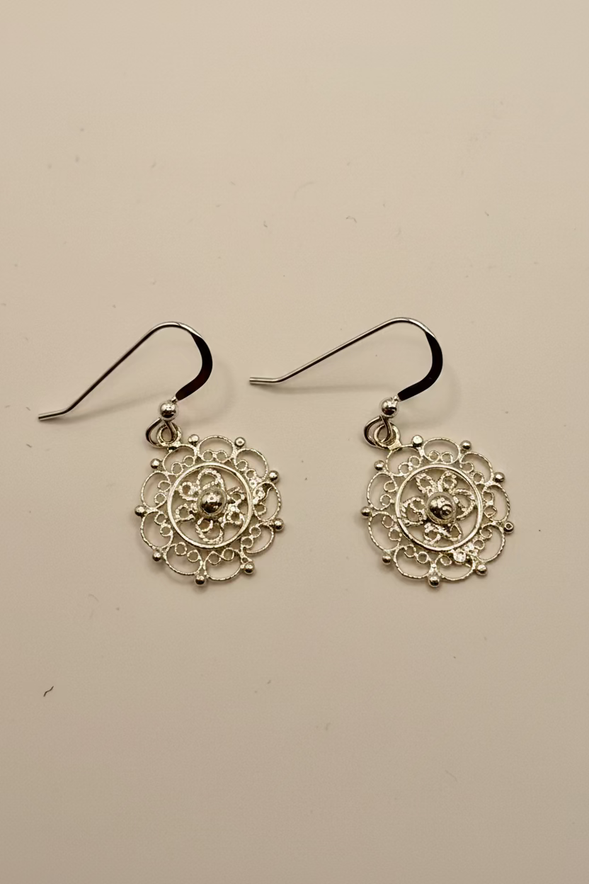 Pair of sterling silver filigree earrings on a white background