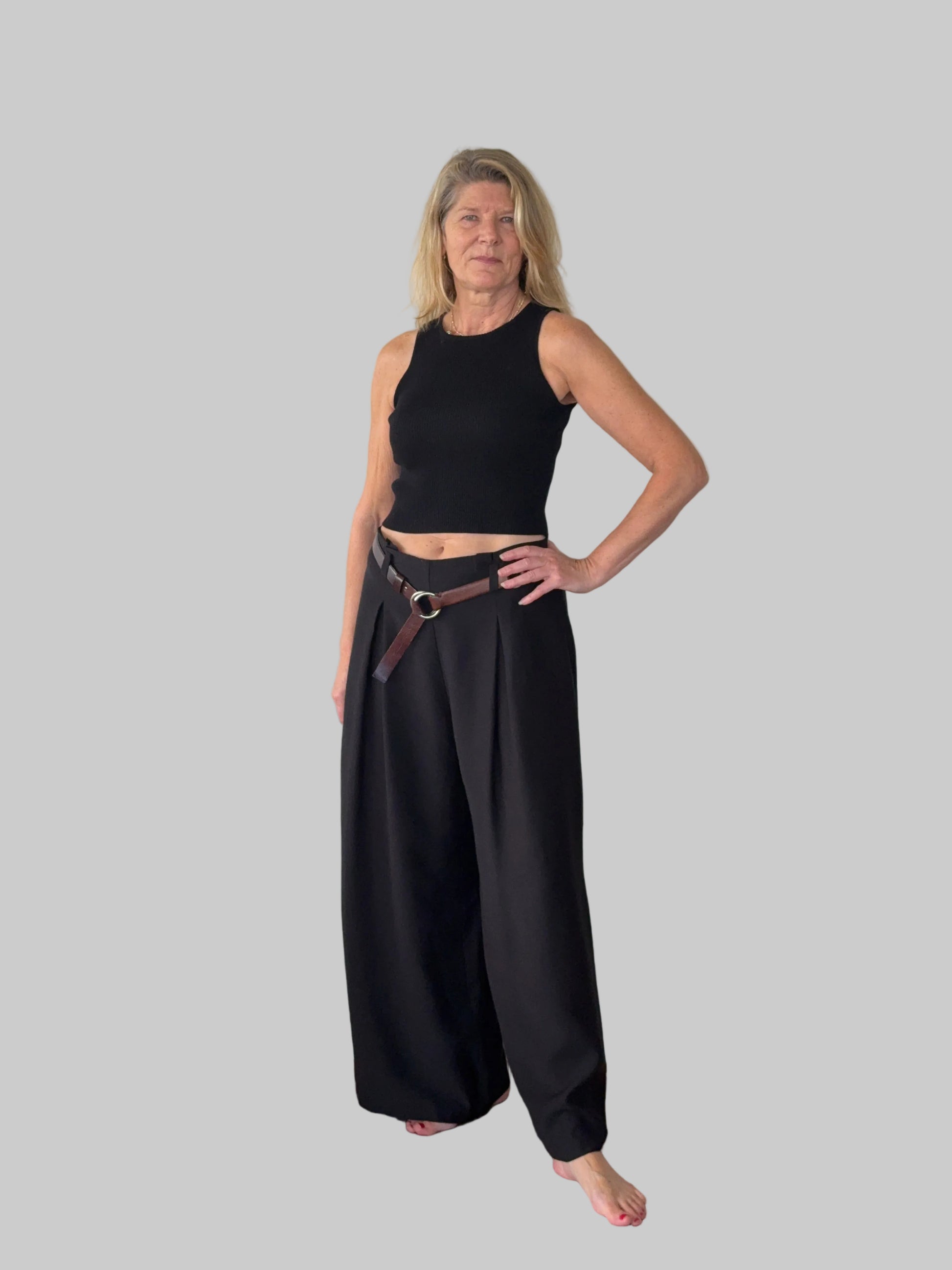 Black flowy wide leg pants women - front view - pleated detail - with belt and black knit tank top - Cheeky Goddess Australia