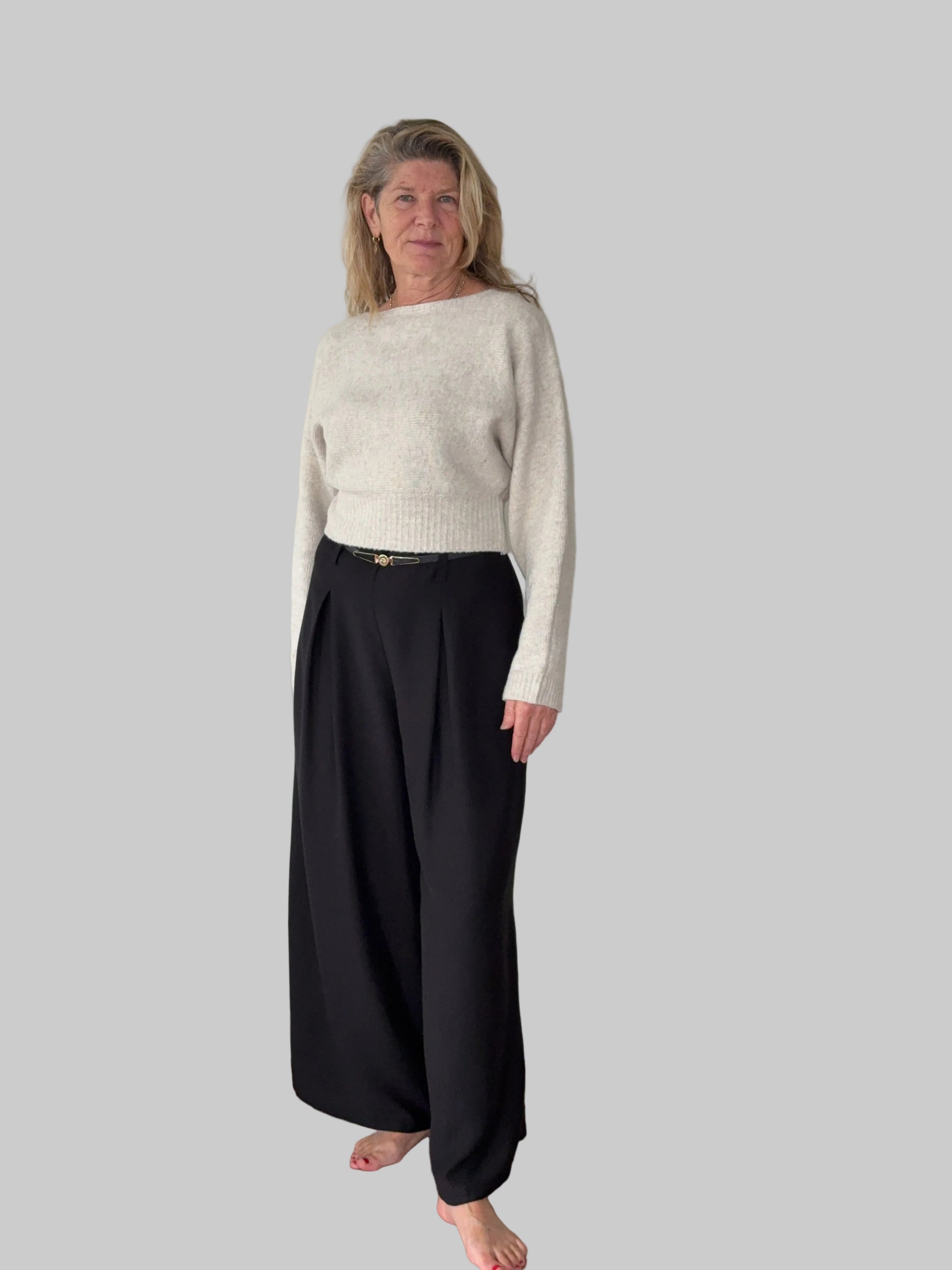 Oversized oatmeal colored batwing knit top with boat neck - women - styled with black pleated wide leg pants - front view - Cheeky Goddess Australia