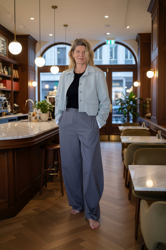 woman wearing grey pants and top in a restaurant