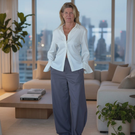 video of woman in a penthouse suite with white shirt and grey pants - cheeky goddess