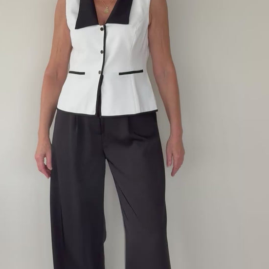 Video of woman in tailored white vest with black contrast - with black paperbag ide leg pants.  Cheeky Goddess - Vida - size 14 - Australia